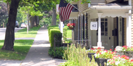 Photo of a home with American flag hanging on porch